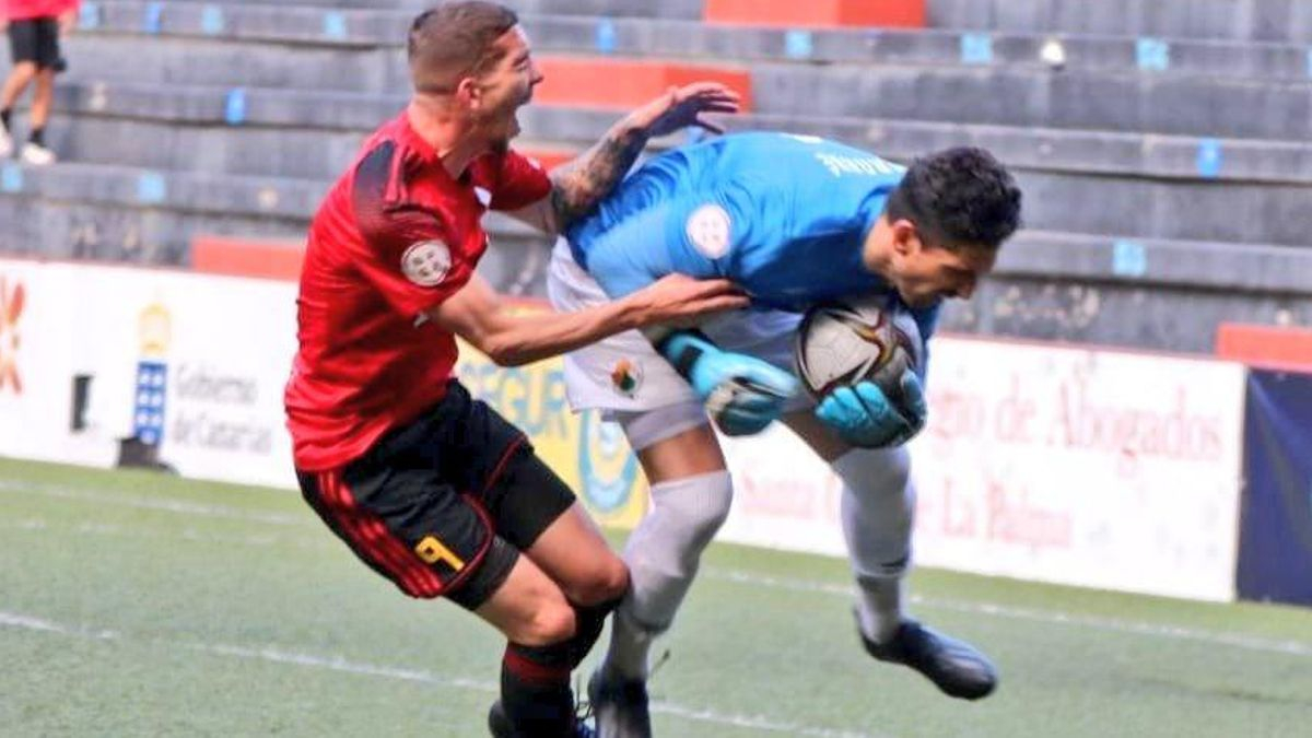 Un jugador del Mensajero choca con Bernabé, portero del Cacereño.