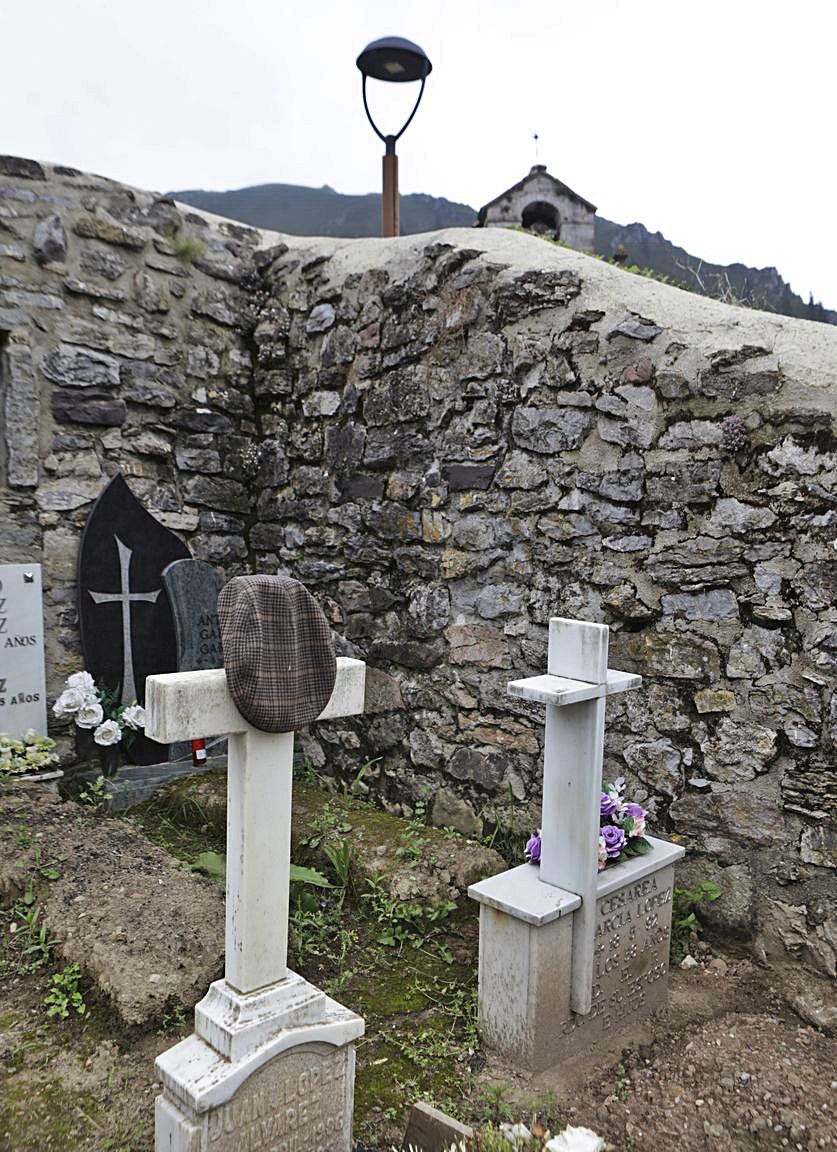 Gorra colgada en la cruz de una tumba del cementerio