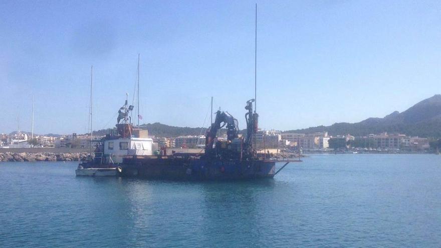 Un barco realiza tareas de dragado en el puerto de Alcúdia.