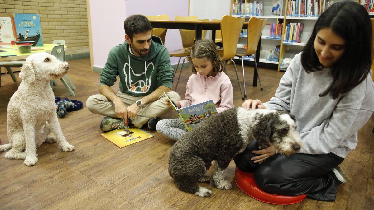 Participantes en un programa de lectura con perros en la biblioteca de El Natahoyo.