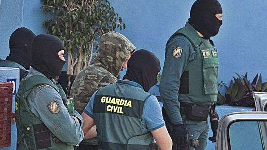 La Guardia Civil desplegó un amplio dispositivo durante la mañana de ayer en el domicilio del detenido, en el barrio de Los Andenes en La Lagiuna. Los agentes permanecieron durante ocho horas registrando la vivienda. En la imagen, el momento en el que salen del edificio con E. M. C. detenido.