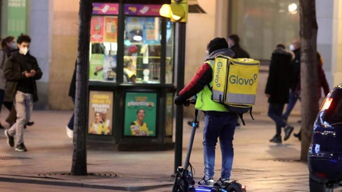 Un repartidor de Glovo en patinete, en Zaragoza.