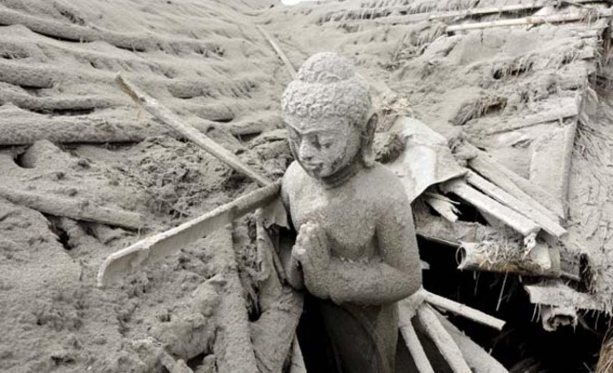 Una estàtua budista està coberta per les cendres del volcà Merapi a Muntilan (Indonèsia). Les autoritats del país han elevat a 141 els morts per l’activitat volcànica.