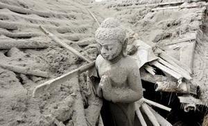 Una estàtua budista està coberta per les cendres del volcà Merapi a Muntilan (Indonèsia). Les autoritats del país han elevat a 141 els morts per l’activitat volcànica.