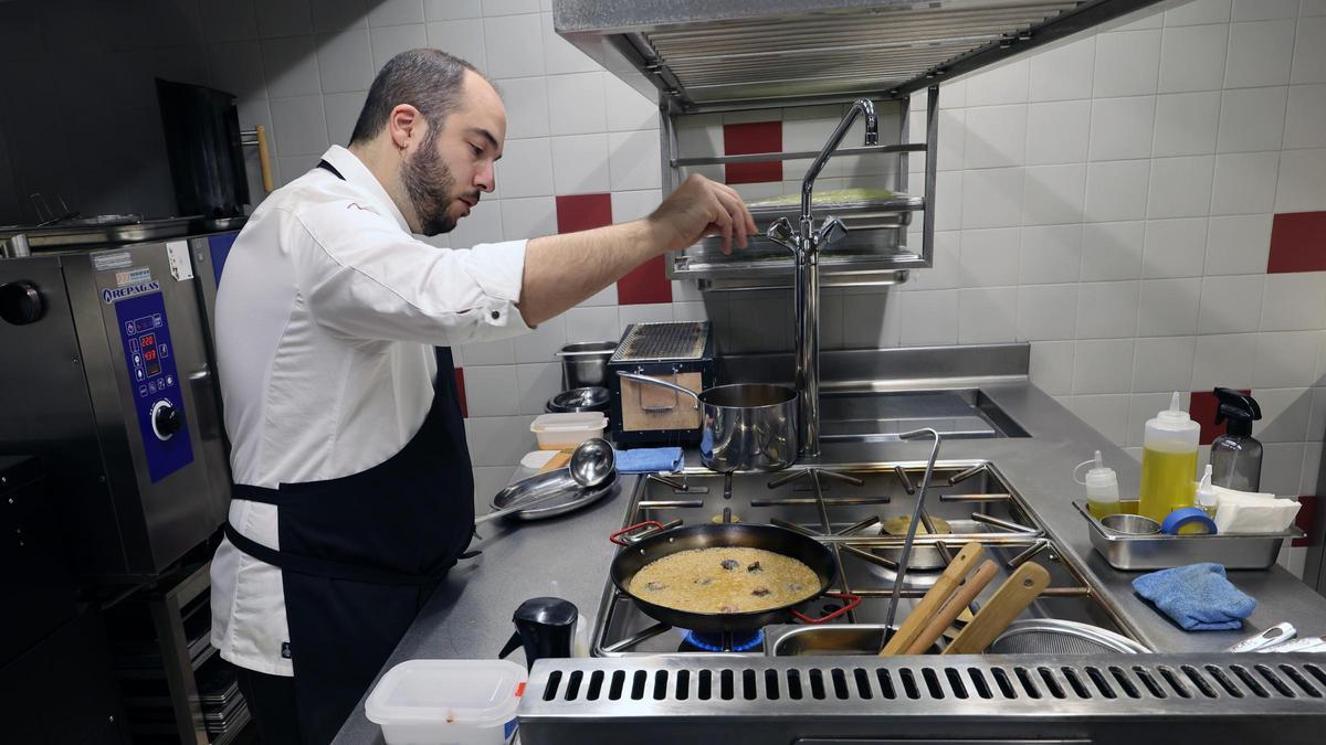 Miguel Pardo, en la cocina de Melós preparando una paella.