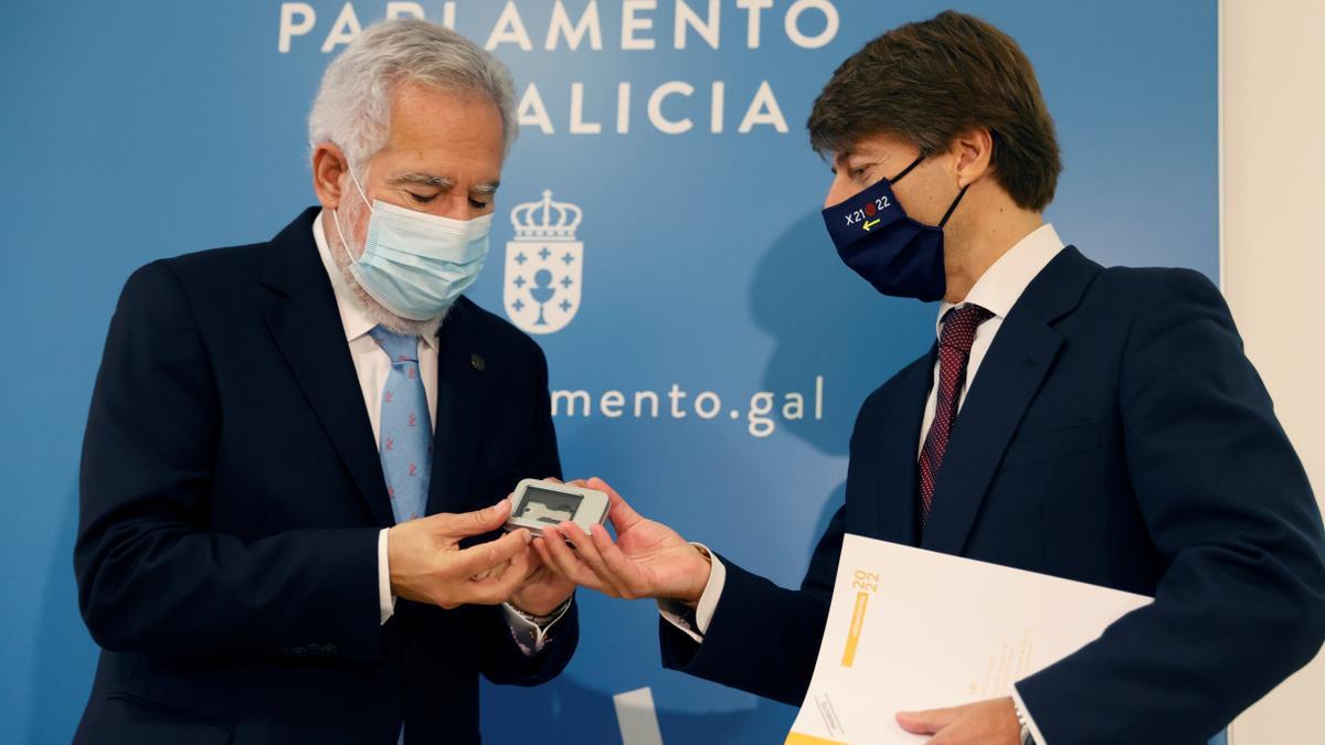 El conselleiro de Facenda, Miguel Corgos, entrega al presidente del Parlamento, Miguel Santalices, el proyecto de ley de presupuestos de Galicia