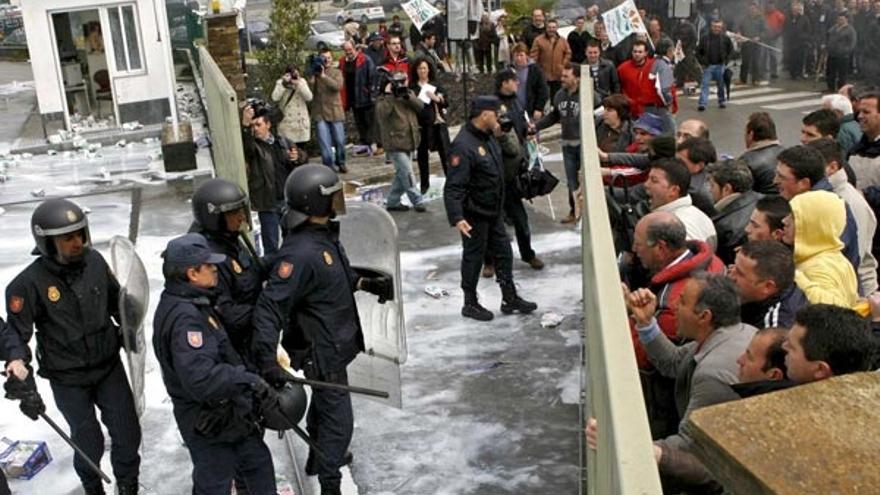 Policías y manifestantes se enfrentan, ayer, durante la concentración frente a una factoría Río.