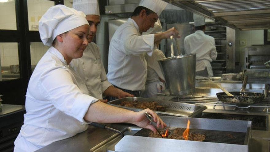 Estudiantes y profesores en las cocinas de la escuela de La Cónsula.