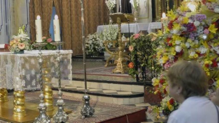 Asistentes a la misa en honor a San Pascual Baylon en la iglesia de San José y las flores de la ofrenda.