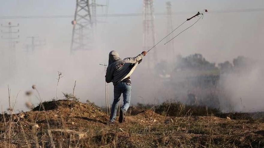 Un palestino lanza piedras contra los soldados israelíes. // Reuters