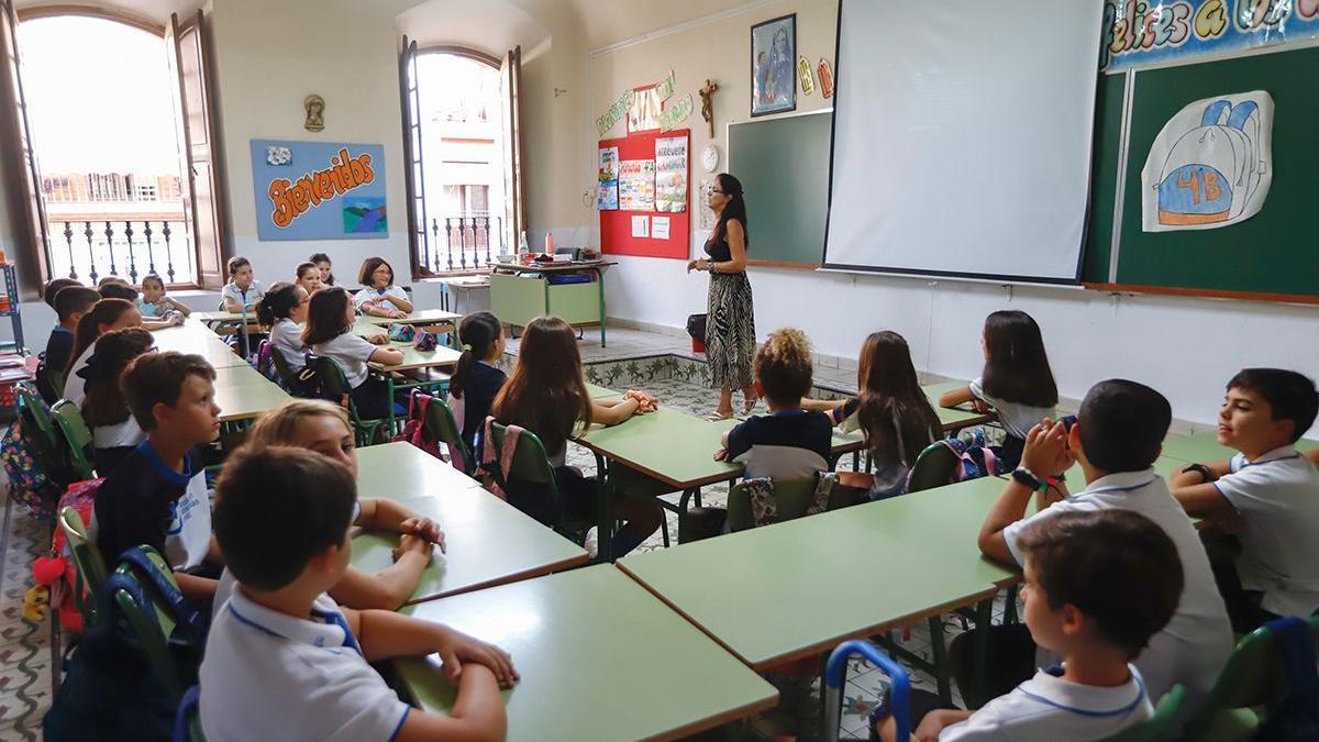 Profesora y alumnos en el aula de un centro escolar.