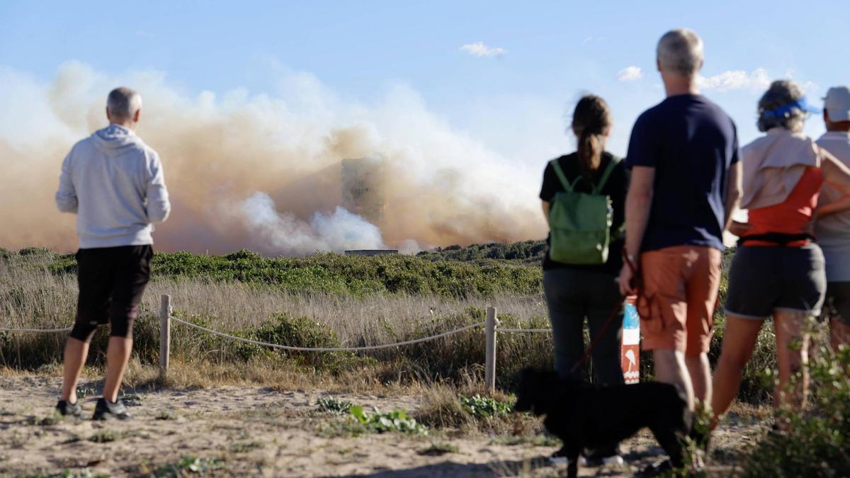 Algunos vecinos del Saler observan desde la lejanía la evolución del fuego que cerca sus casas