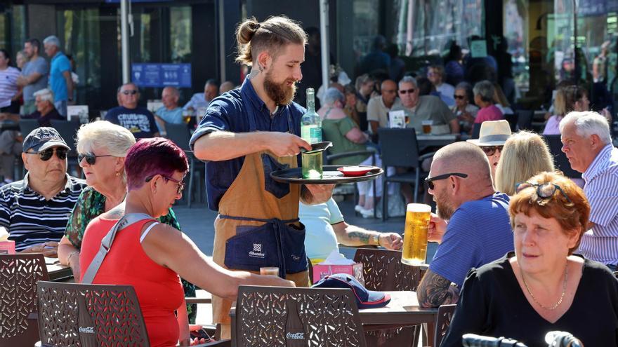 Un camarero atiende a un grupo de clientes en una terraza de Vigo.