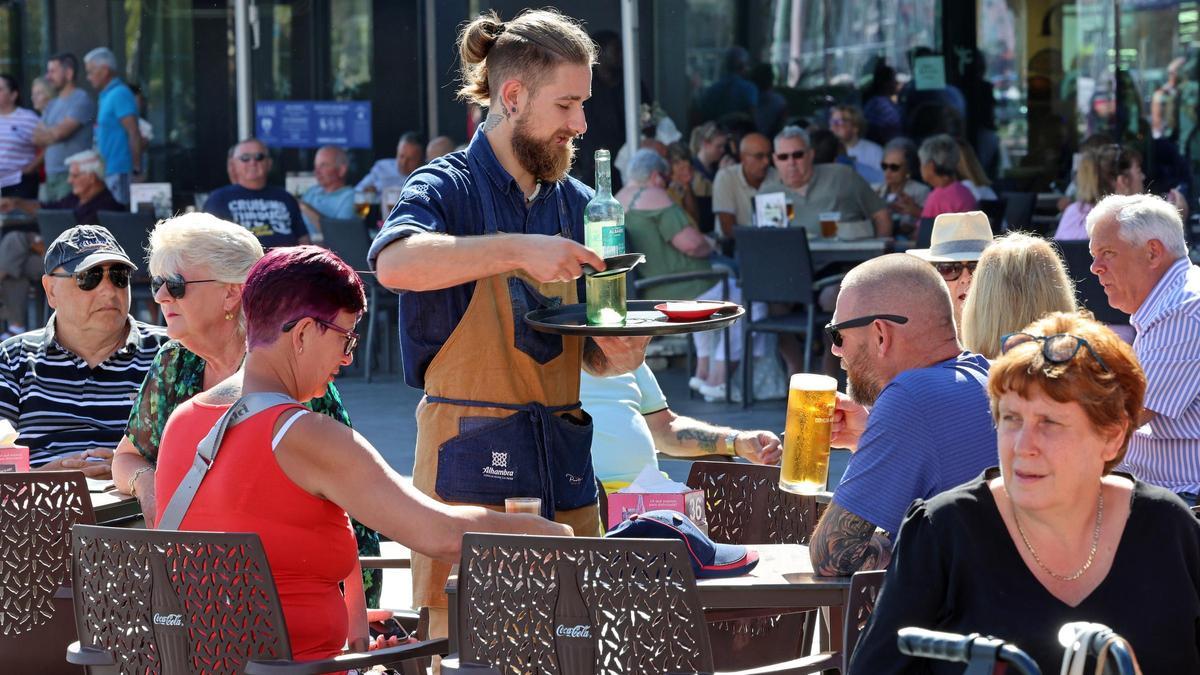 Un camarero atiende a un grupo de clientes en una terraza de Vigo.