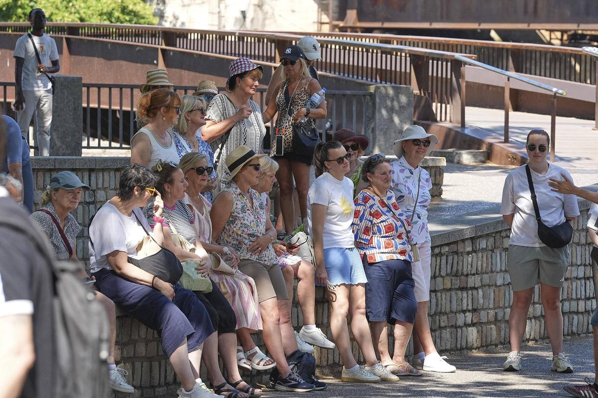 Turistes a l'ombra durant la visita pel barri vell.