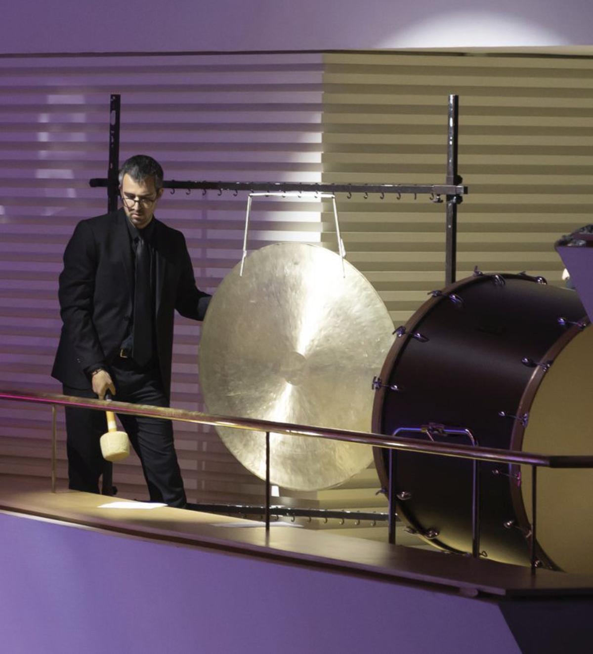 A la izquierda, uno de los músicos de la ADDA Simfònica tocando el tam-tam; a la derecha, el maestro Josep Vicent. |