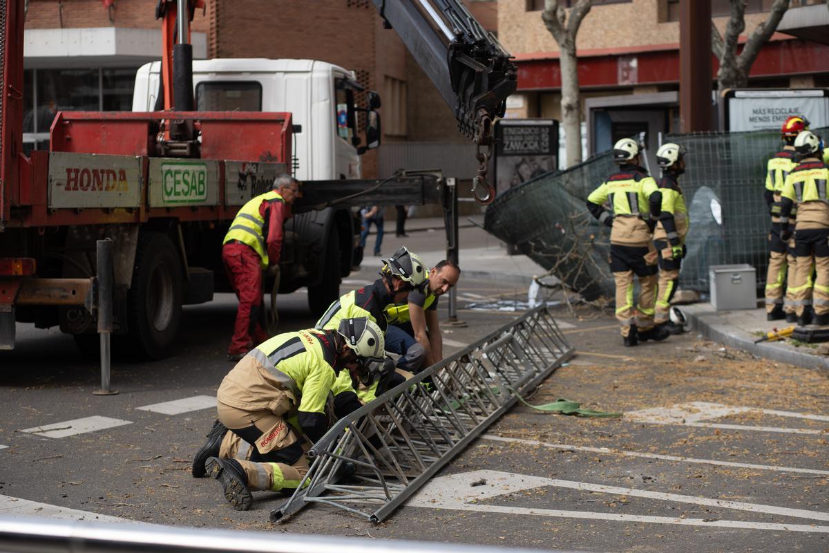 Los bomberos cortan la guía para facilitar el trabajo de la grúa que despejó la zona del siniestro.