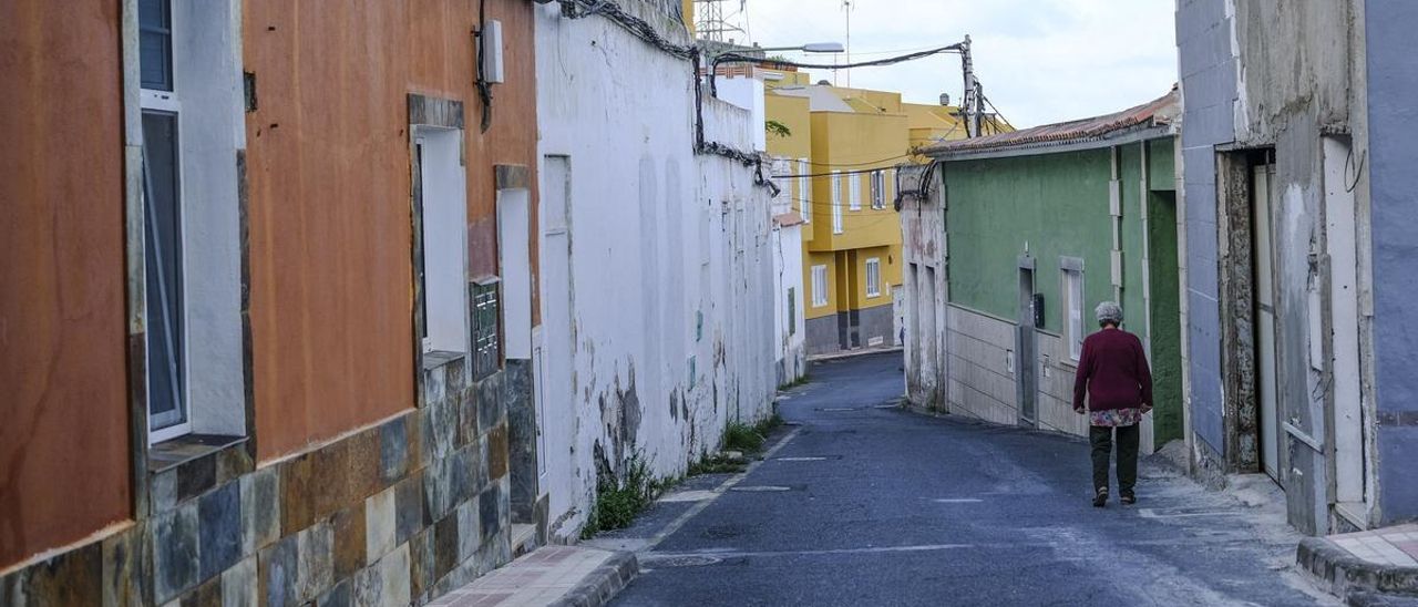 Una vecina del barrio de Los Riscos pasea por la calle.
