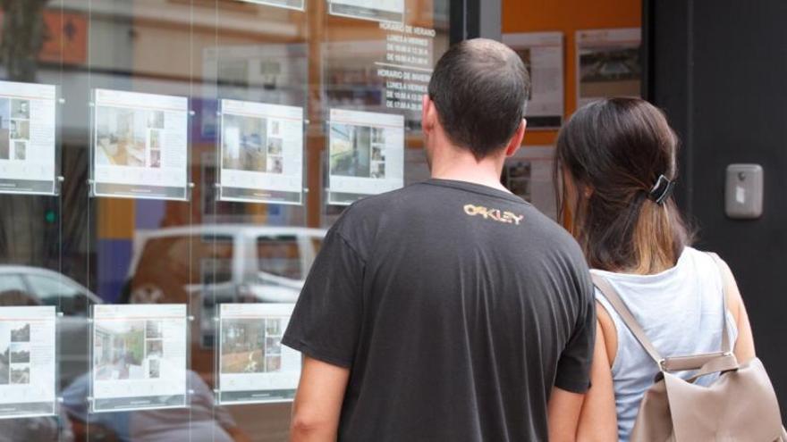 Imagen de archivo de dos personas viendo el escaparate de una inmobiliaria