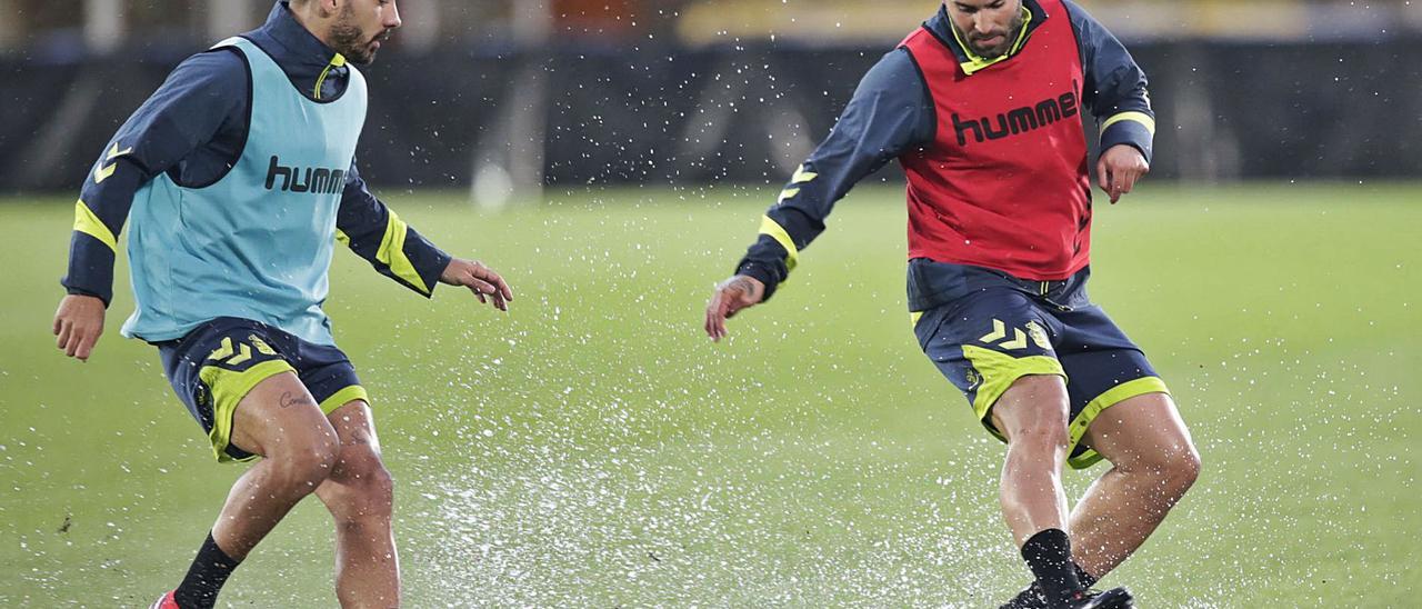Jesé Rodríguez maneja el balón ante la presencia de Álex Suárez durante el entrenamiento de ayer, pasado por agua, en el Estadio de Gran Canaria. | | LP/DLP