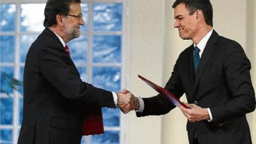 Rajoy i Sánchez fan una encaixada de mans per escenificar el seu acord contra el gihadisme.