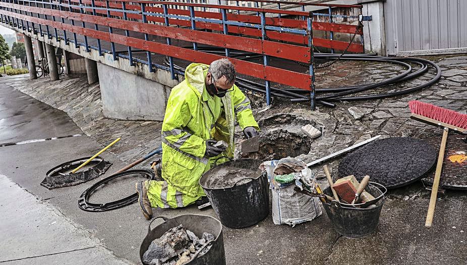 Un operario trabaja en la reparación de la avería del colector que provocó inundaciones en la zona del Palacio de los Deportes de Oviedo. | I. Collín