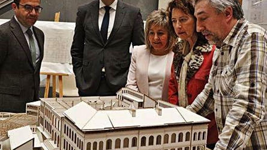 La directora y miembros de la Junta atienden a las explicaciones sobre la maqueta del edificio.