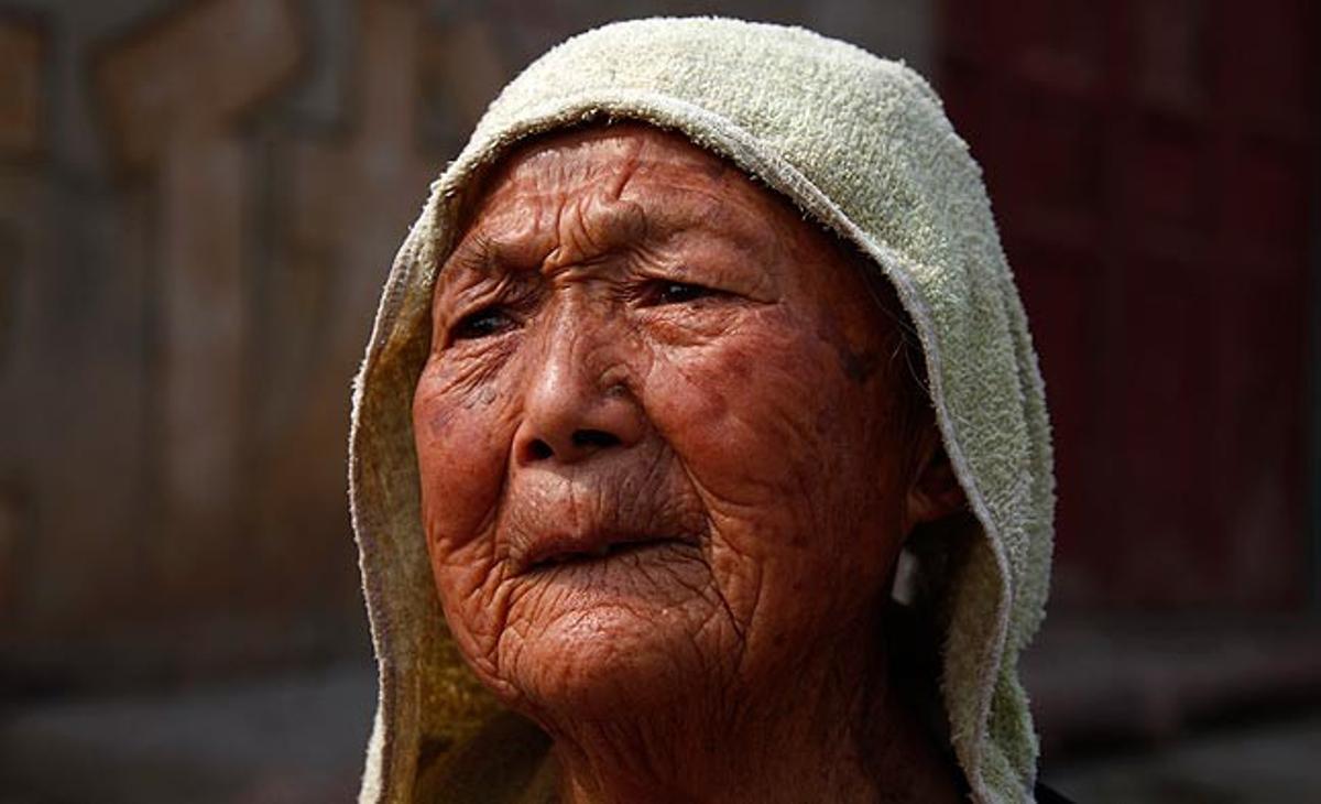Una mujer de 95 años observa este pasado domingo unos pescadores en uno de los canales del río chino de Yangtze, que está prácticamente seco como consecuencia del cambio climático.