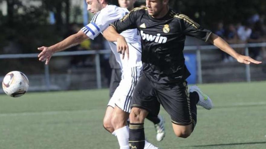 Rubén Rivera, de blanco, pugna por el balón con un futbolista del Castilla. / fran martínez