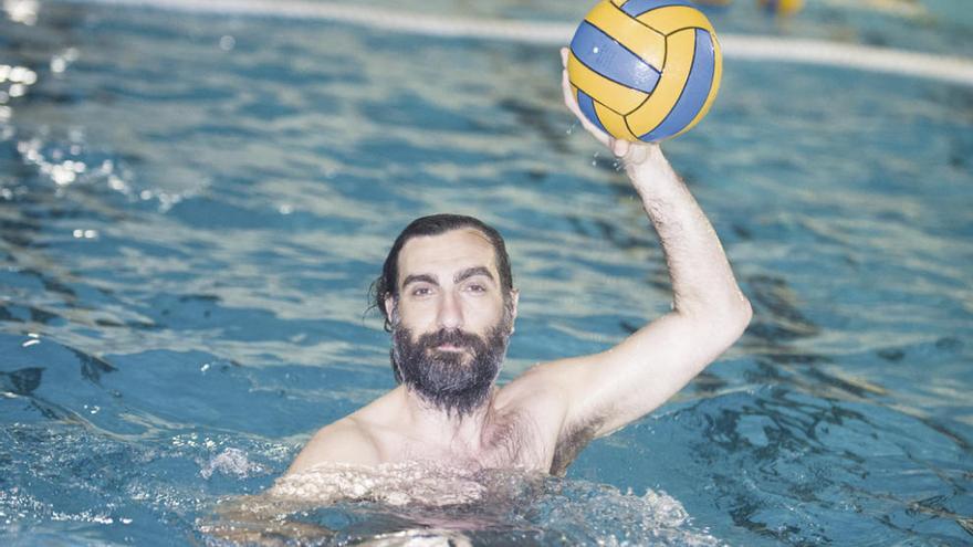 Jose García posa con el balón de waterpolo en alto en la piscina de INEF de Bastiagueiro.