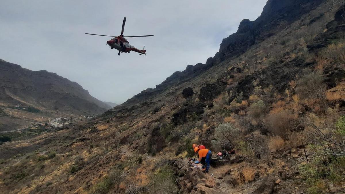 Los voluntarios de Protección Civil atienden junto al rescatador del GES a la senderista.