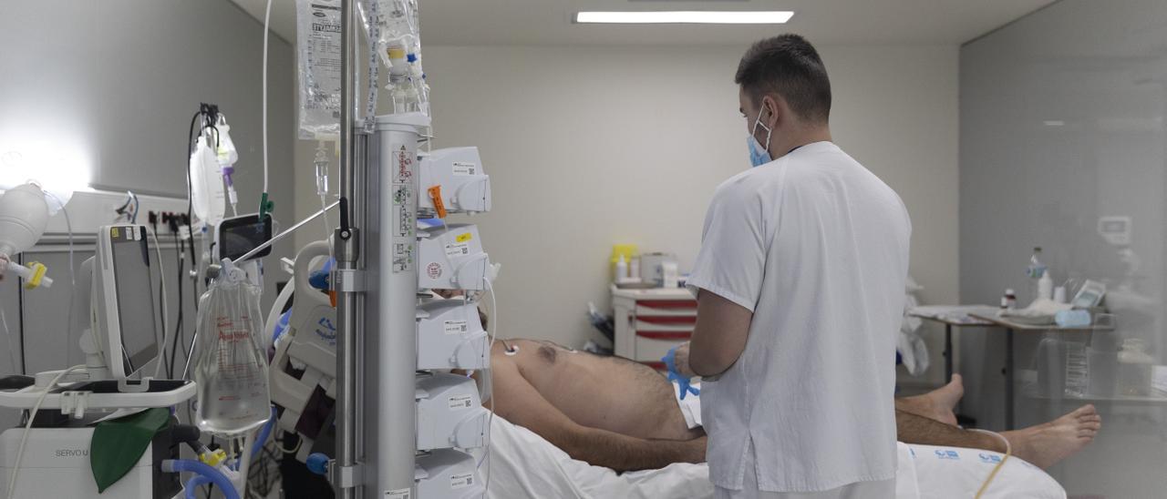 Archivo - Un sanitario alrededor de un paciente ingresado en la UCI d de un hospital.