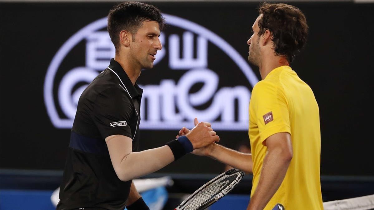 Djokovic recibe la felicitación de Ramos tras su partido de tercera ronda en Melbourne.