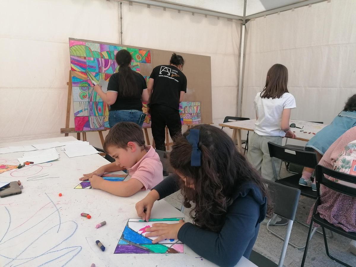 Niños pintan algunos de los cuadros que conforman el mural ideado por Adeva durante el taller.