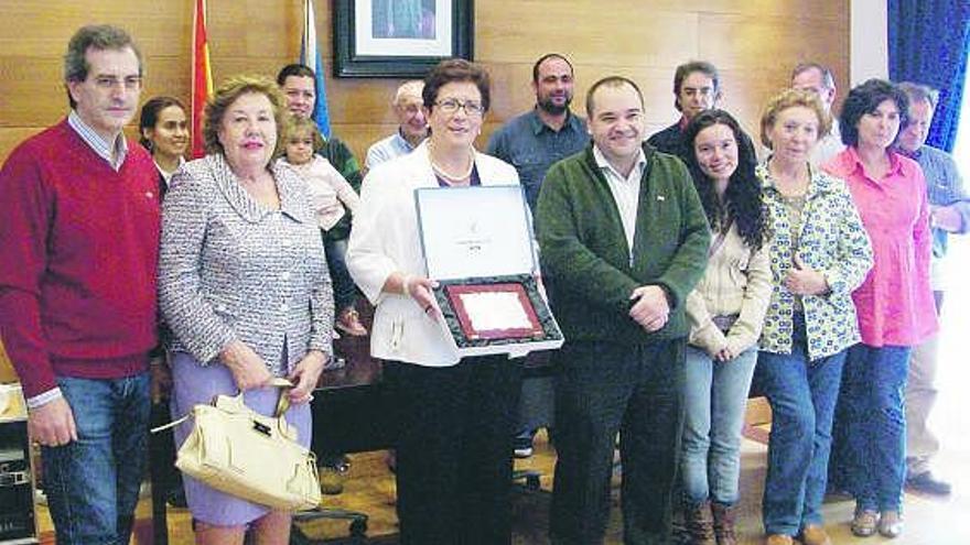 Maria Felisa Fontaniella posa con la placa junto a autoridades, compañeros y familiares, ayer, en Cangas.