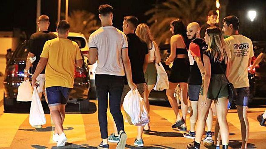 Jóvenes portando bolsas con bebidas en las calles de Cabo de Palos durante uno de los botellones de las últimas semanas.