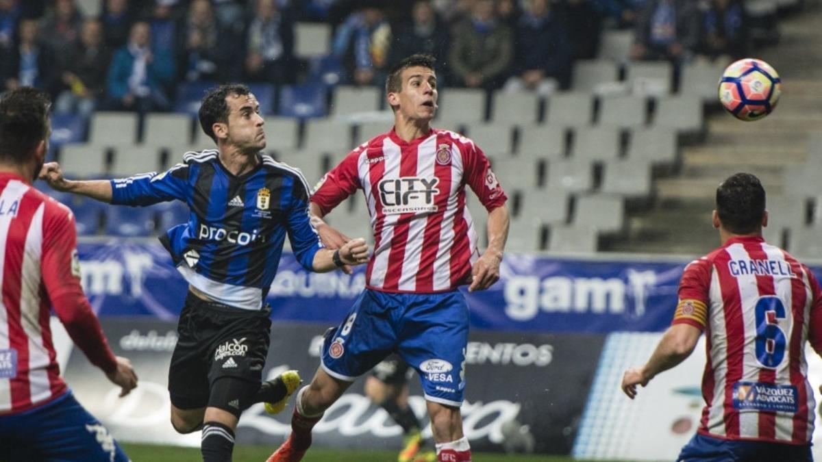 El jugador del Girona Pere Pons trata de despejar ante un jugador del Oviedo.