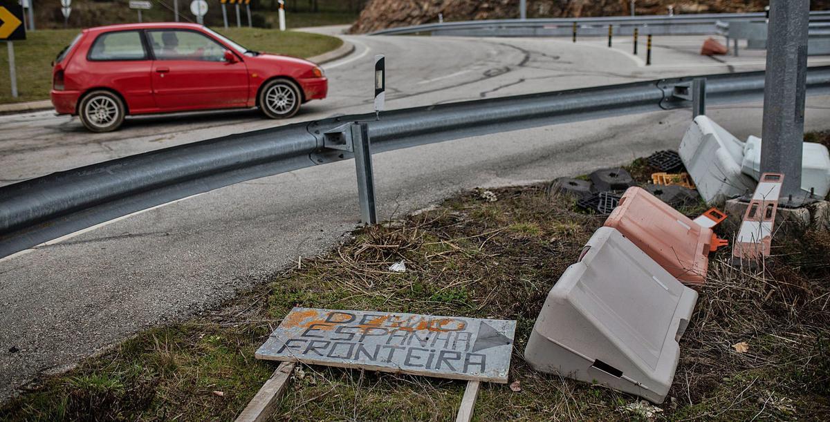 Un coche pasa por una rotonda al pie de la frontera, ante un cartel en el suelo que marca el desvío hacia España. | Emilio Fraile