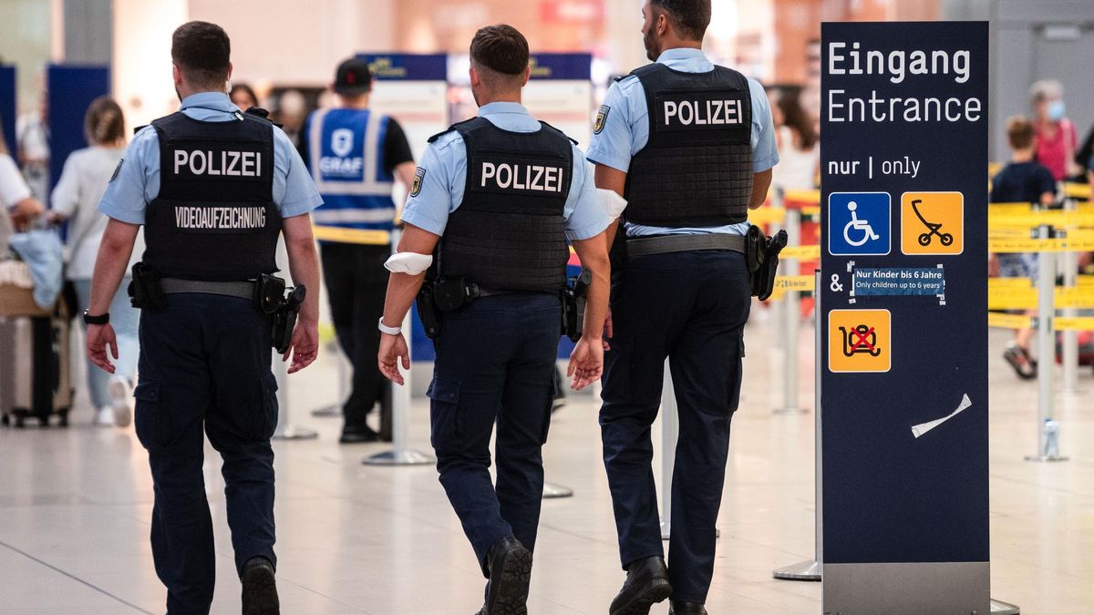 Beamte der Bundespolizei gehen an den Sicherheitskontrollen des Flughafens Köln/Bonn vorbei.