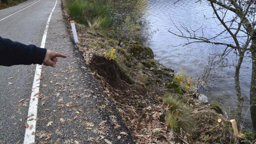 Una persona muestra una de las zonas de la carretera afectada por los derrumbes.