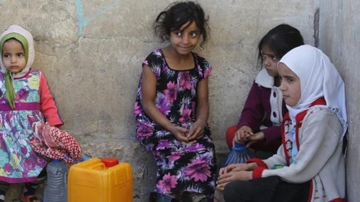 Niñas yemenís esperan para coger agua en una fuente potable en Saná.