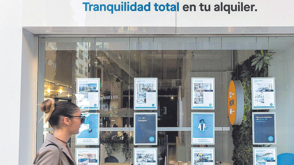 Una mujer pasa frente a una agencia de alquileres de vivienda en Alicante.