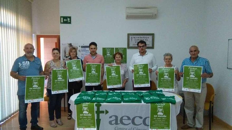 Responsables de la asociación y autoridades muestran el cartel anunciador de la marcha.