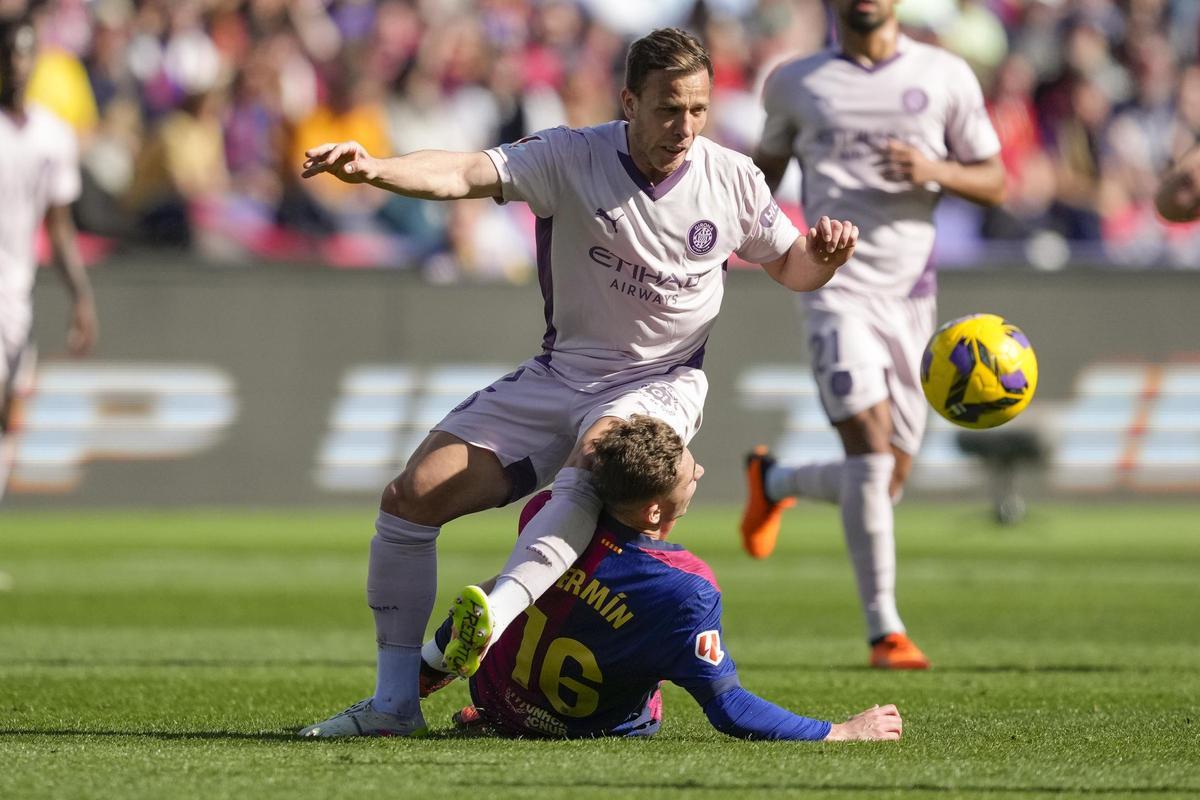 Arthur Melo disputa un balón con Fermín.