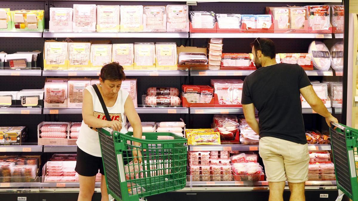 Dos personas hacen la compra en un supermercado.