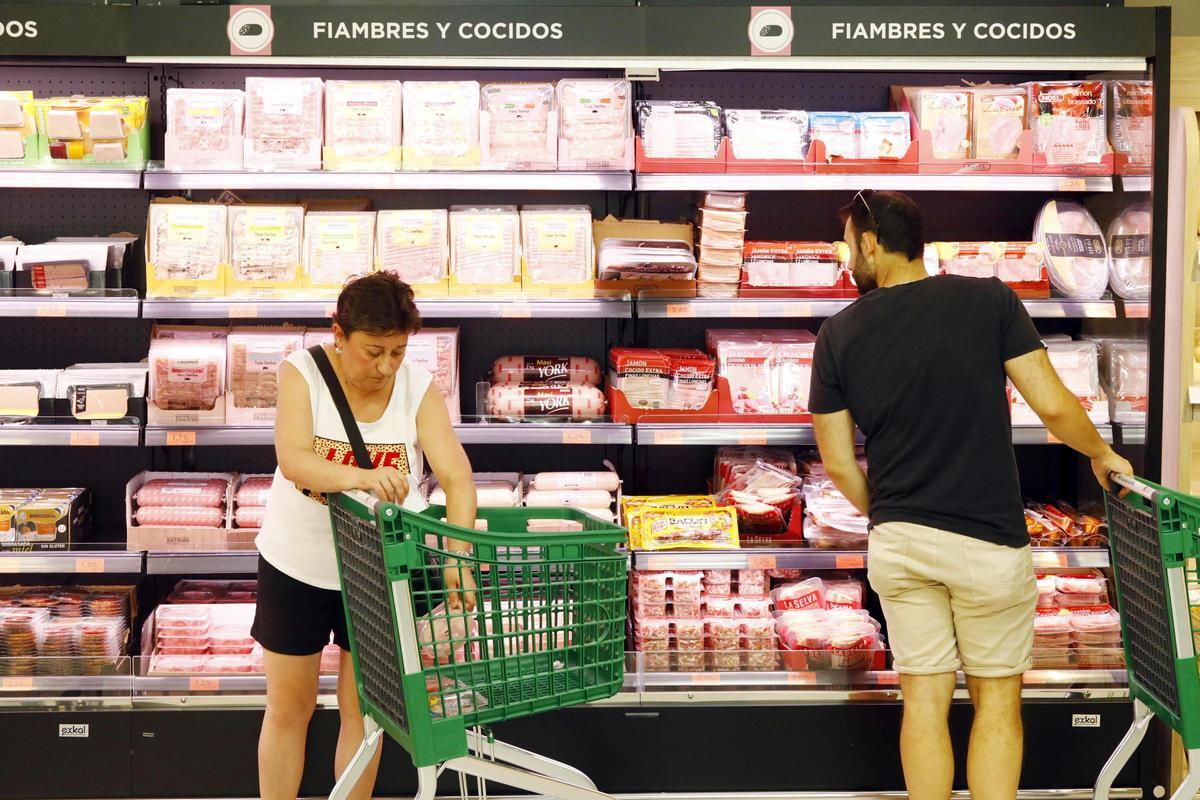 Dos personas hacen la compra en un supermercado.