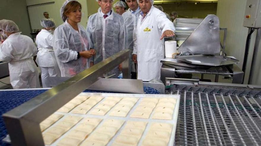 Ramón Dourado, a la derecha, muestra la cadena de producción de Lamastelle a Feijóo y Beatriz Mato.