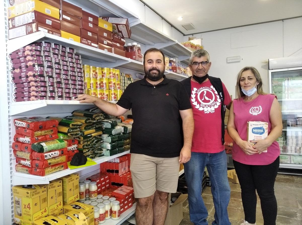 Víctor Fernández (izq.), con dos voluntarios en el economato social de Animación Malacitana en Campanillas.