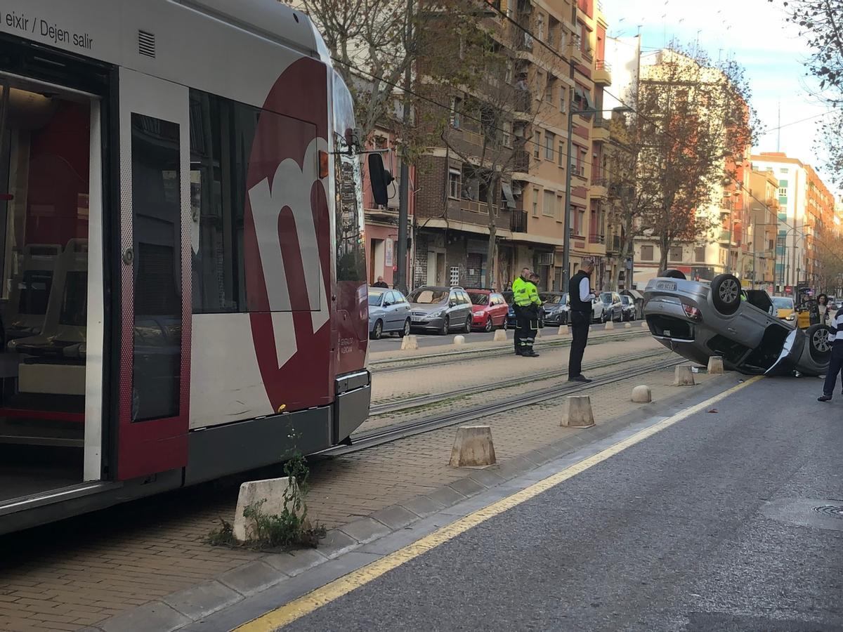 Un coche vuelca en las vías del tranvía en la Calle Actor Mora de València.