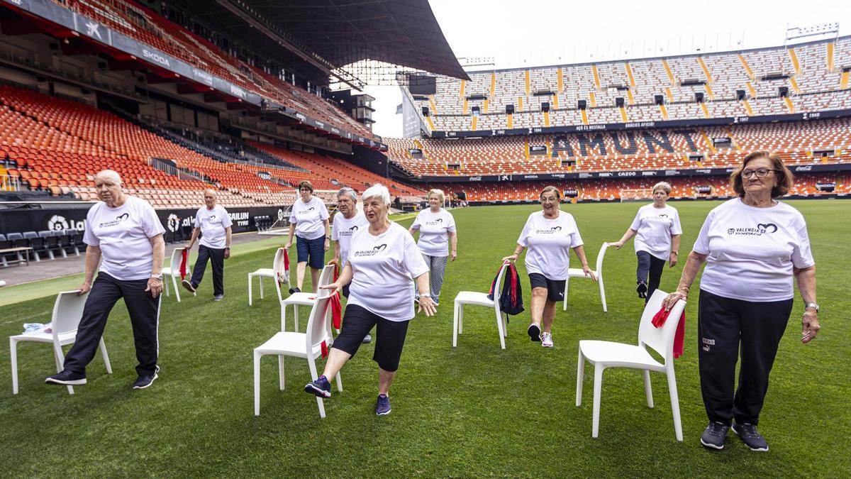 Grupo de personas mayores, relacionadas con el Valencia CF, practicando ejercicio en Mestalla.
